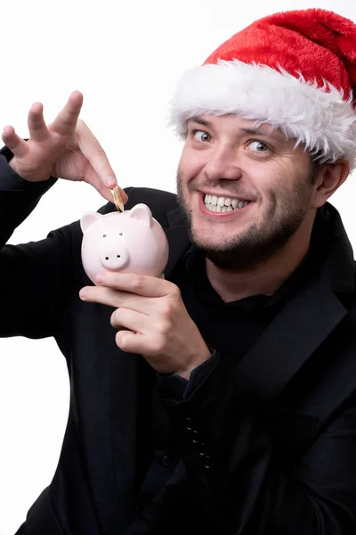 Изображение счастливого человека в шляпе Санты с игрушечной свиньёй — стоковое фото