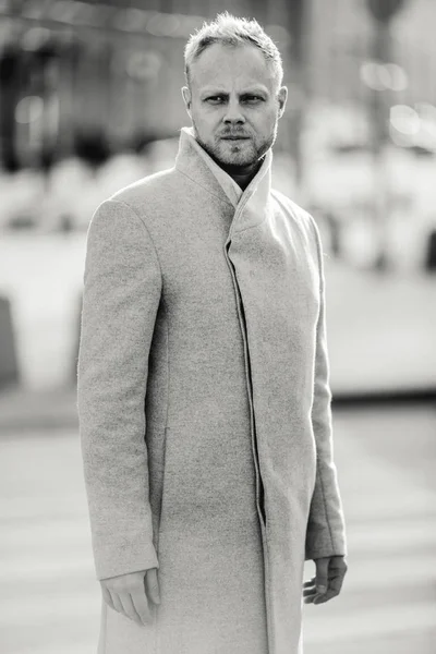 Czarno-biały portret młodzieńca w płaszcz na ulicy, — Zdjęcie stockowe