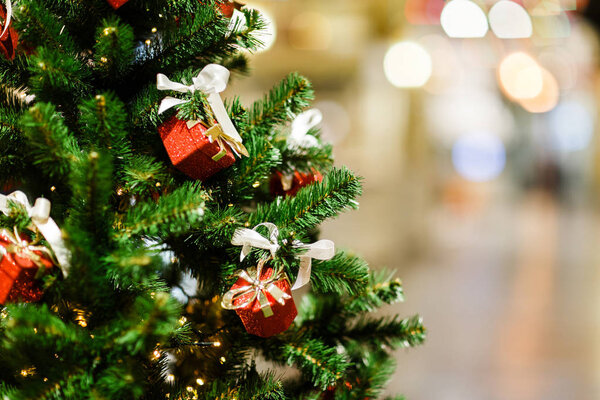 Изображение украшенной елки с красными подарочными коробками в магазине
