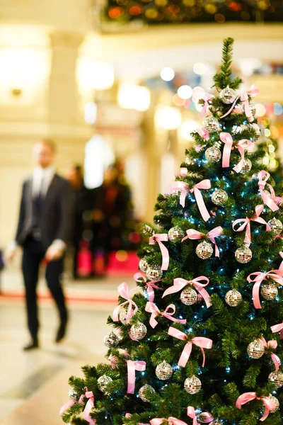Bild des Weihnachtsbaums mit Kugeln mit Pailletten, rosa Schleifen auf verschwommenem Hintergrund — Stockfoto