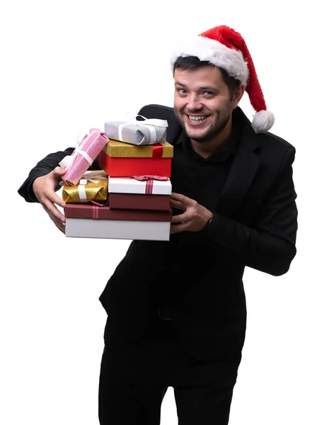 Imagen de la feliz morena en sombrero de santa con cajas con regalos en las manos sobre fondo blanco en blanco —  Fotos de Stock
