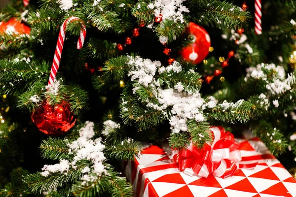 Φωτογραφία: χριστουγεννιάτικο δέντρο με κόκκινα μπαλάκια, καλάμια καραμέλα, δώρο — Φωτογραφία Αρχείου
