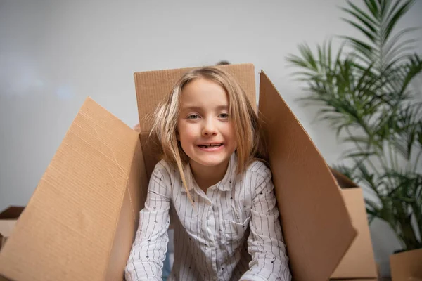 Boldog lány látszó-ből cardboard box-fotó — Stock Fotó