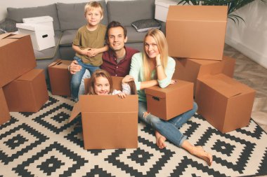 Oğlum ve kızım karton kutular arasında katta oturan ile genç çift