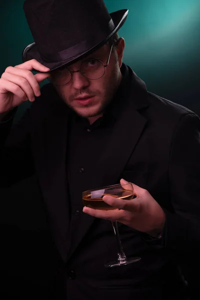 Zdjęcie mężczyzna w czarnym kapeluszu ze szkłem w ręce — Zdjęcie stockowe