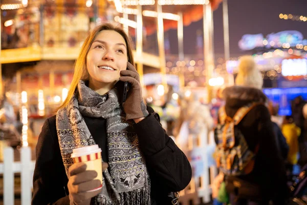 Foto einer glücklichen Frau mit Glas und Handy in der Hand am Abend zum Spaziergang — Stockfoto