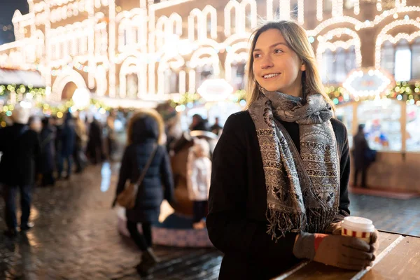 Foto eines jungen Mädchens mit einem Glas Kaffee in der Hand auf einem Winterspaziergang in der Stadt — Stockfoto