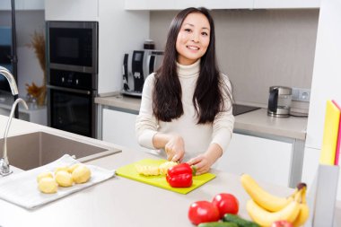 Fotoğraf mutlu esmer kesme patates sebze ve meyve ile masada