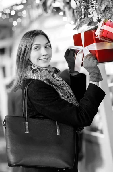 Foto en blanco y negro de mujer feliz con vidrio en las manos cerca de cajas con regalos —  Fotos de Stock
