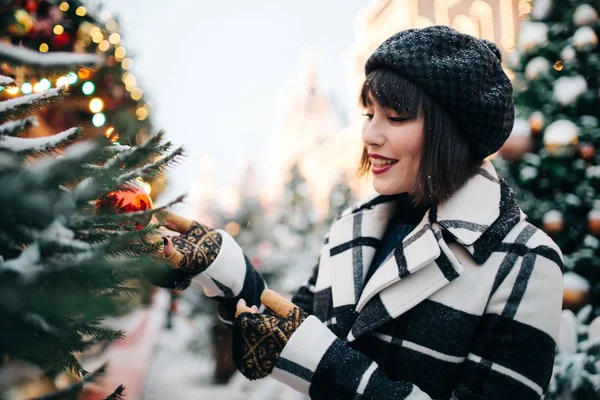 Foto de joven morena cerca del árbol de Navidad pintado en la calle —  Fotos de Stock