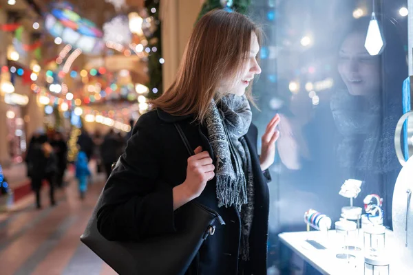 晚上商店橱窗里年轻女子的形象一面 — 图库照片