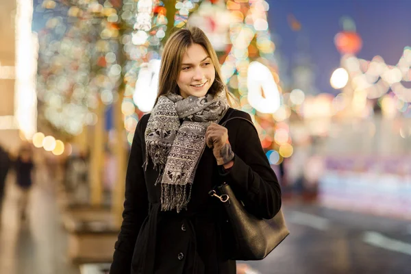 Foto einer Frau außerhalb der Stadt auf verschwommenem Hintergrund mit Girlanden — Stockfoto