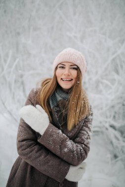 Kış ormandaki yürüyüşte şapkalı gülümseyen kadın portresi