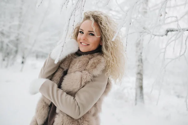 Immagine di donna bionda felice a piedi nella foresta invernale — Foto Stock