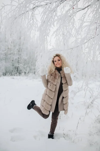 Imagen de la mujer rubia feliz en un paseo por el bosque de invierno —  Fotos de Stock