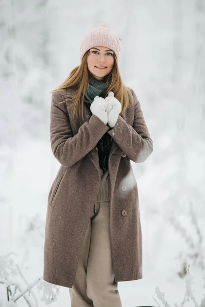 Imagen de la chica rubia feliz en sombrero a pie en el bosque de invierno —  Fotos de Stock