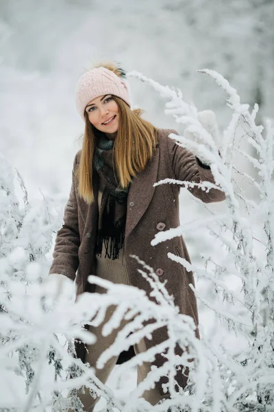 Porträtt av leende kvinna i hatt på promenad i vinter skog — Stockfoto