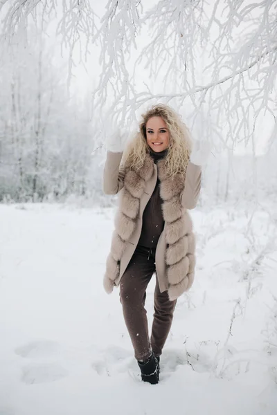 Образ щасливої блондинки на прогулянці в зимовому лісі — стокове фото