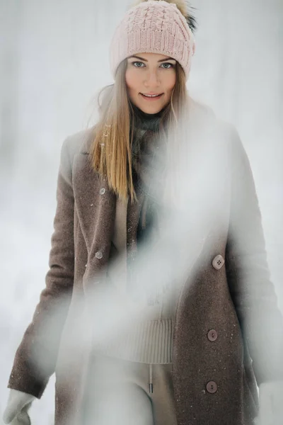 Bild av glada blond kvinna i hatt på promenad i vinter skog — Stockfoto
