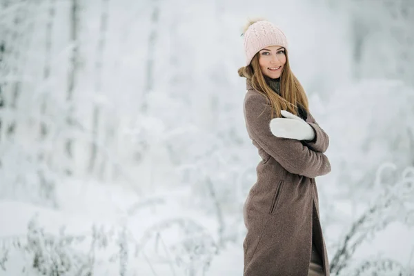 Ritratto di donna bionda in cappello a piedi nella foresta invernale — Foto Stock