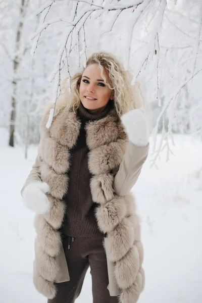 Imagen de la mujer rubia feliz en un paseo por el bosque de invierno —  Fotos de Stock