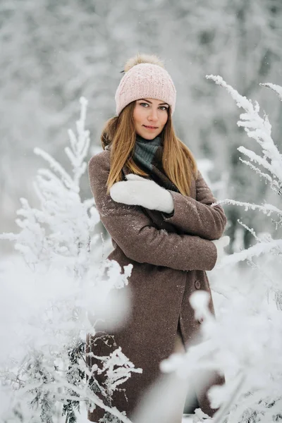 Ritratto di donna sorridente in cappello a piedi nella foresta invernale — Foto Stock