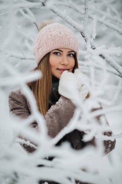 Kış ormandaki yürüyüşte şapkalı gülümseyen kadın portresi