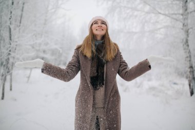 Photo of happy blonde woman on walk in winter forest clipart