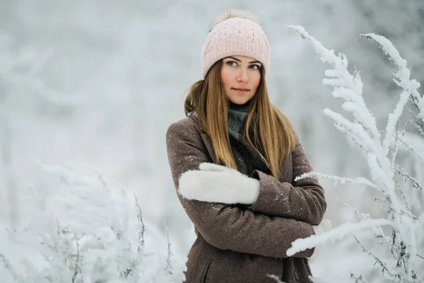 Retrato de mulher sorridente em chapéu no passeio na floresta de inverno — Fotografia de Stock