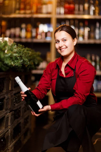 Immagine di bruna felice con bottiglia di vino accovacciato — Foto Stock