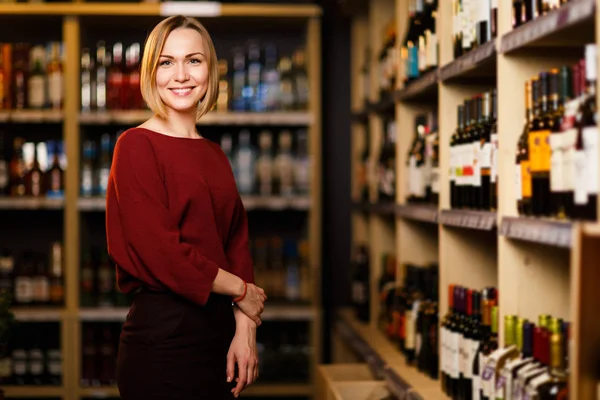 Image de femme blonde heureuse en magasin avec du vin — Photo