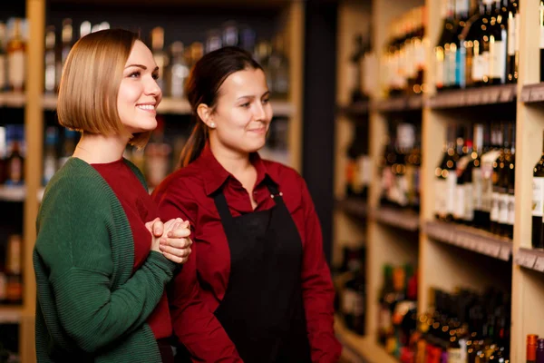 Immagine a lato di due donne felici in negozio sullo sfondo di scaffali — Foto Stock