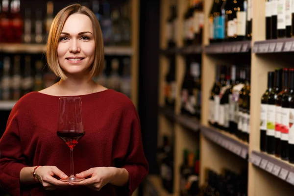 Immagine di donna con vetro in mano in negozio con il vino — Foto Stock
