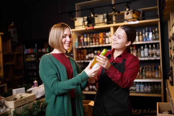 Foto de duas mulheres com garrafa de vinho na mão — Fotografia de Stock