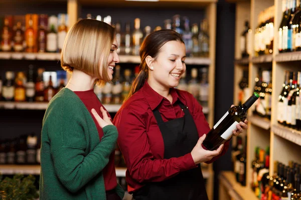 Immagine del venditore e compratore su sfondo sfocato di scaffali con bottiglie di vino — Foto Stock