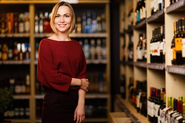 Image de femme blonde heureuse en magasin avec du vin — Photo