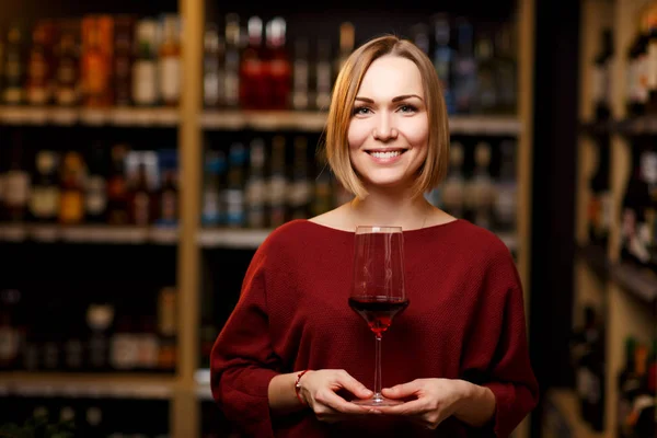 Şarap ile mağazada elinde cam ile kız fotoğrafı — Stok fotoğraf