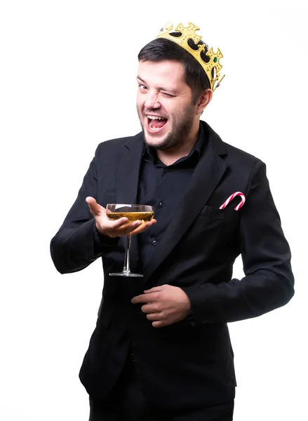 Człowiek w koronę, czarny kombinezon z kieliszek do wina w ręku . — Zdjęcie stockowe