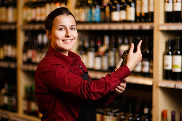 Immagine di donna felice con bottiglia in mano in enoteca — Foto Stock