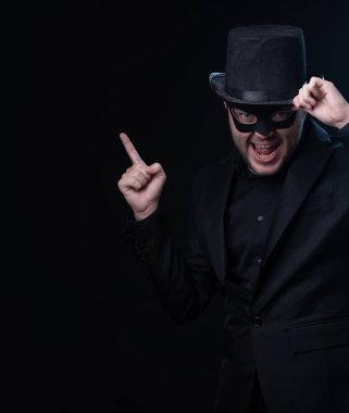 Siyah maske, ceket, boş siyah arka planda şapka adam