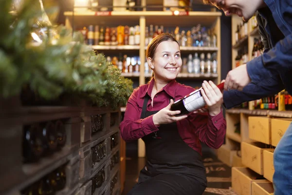 Foto de mulher vendedor com garrafa de vinho e comprador — Fotografia de Stock