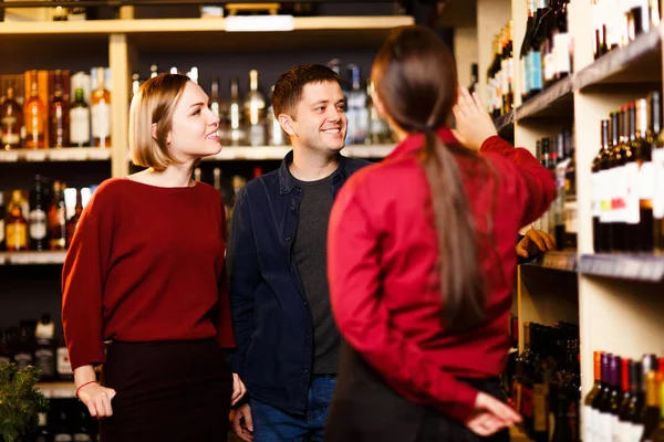 Immagine di donna, uomo e venditore di nuovo in negozio con il vino — Foto Stock