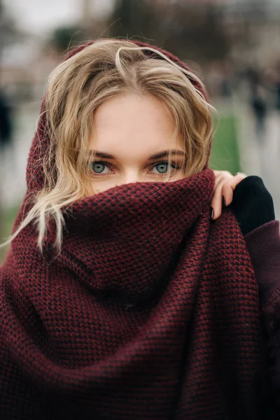 Foto de mujer rubia joven con bufanda de cara cerrada al aire libre . —  Fotos de Stock