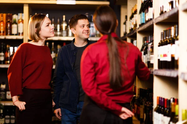 Immagine di donna, uomo e venditore da dietro in negozio con il vino — Foto Stock