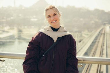 Fotoğraf ceket ayakta windows karşı mutlu sarışın