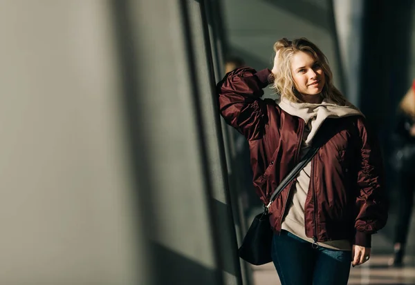 Foto der Blondine in Jacke, die gegen Fenster steht — Stockfoto