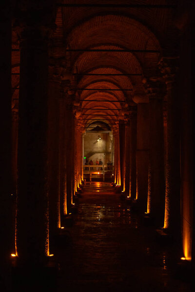 Изображение темной пещеры с лампами и туристами
.