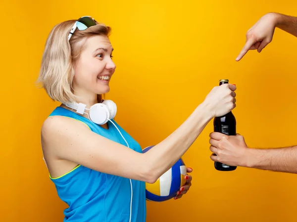 Mujer elige entre el voleibol y la botella de cerveza en el estudio — Foto de Stock