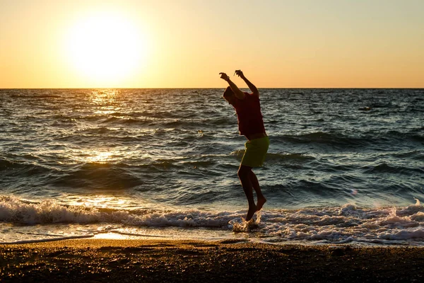 Photo de l'homme heureux sautant sur le rivage — Photo