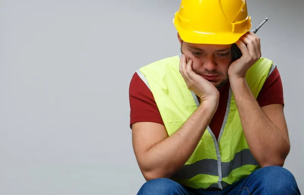 Foto de constructor molesto masculino en casco amarillo con walkie-talkie — Foto de Stock